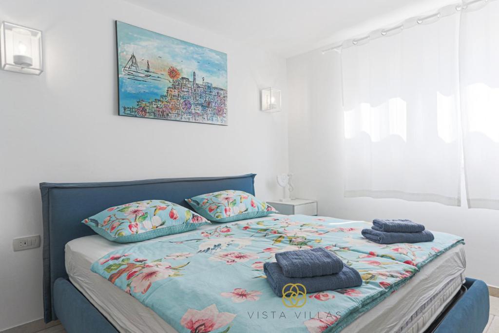 Bedroom with blue bed and sea-inspired artwork at Salty Kisses, Villa S