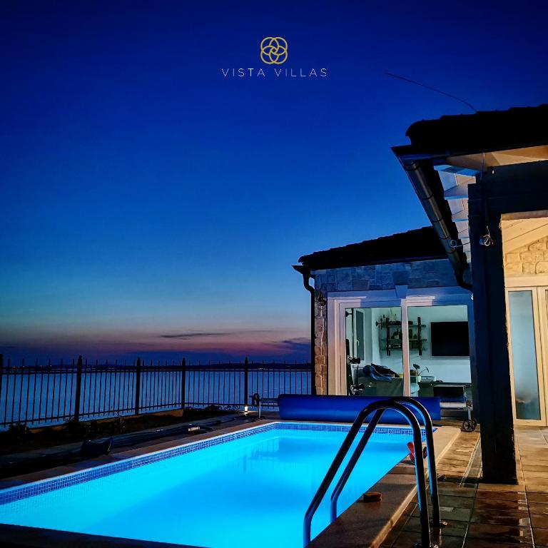 Illuminated private pool at dusk with a sea view