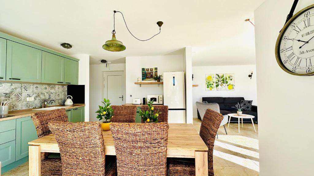 Open kitchen with green cabinets and dining table in Endless Summer