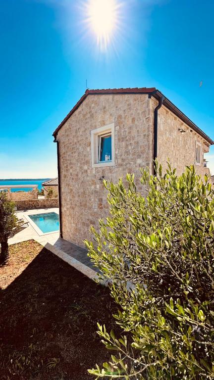 Pool terrace with a sea view beyond the stone walls at Endless Summer